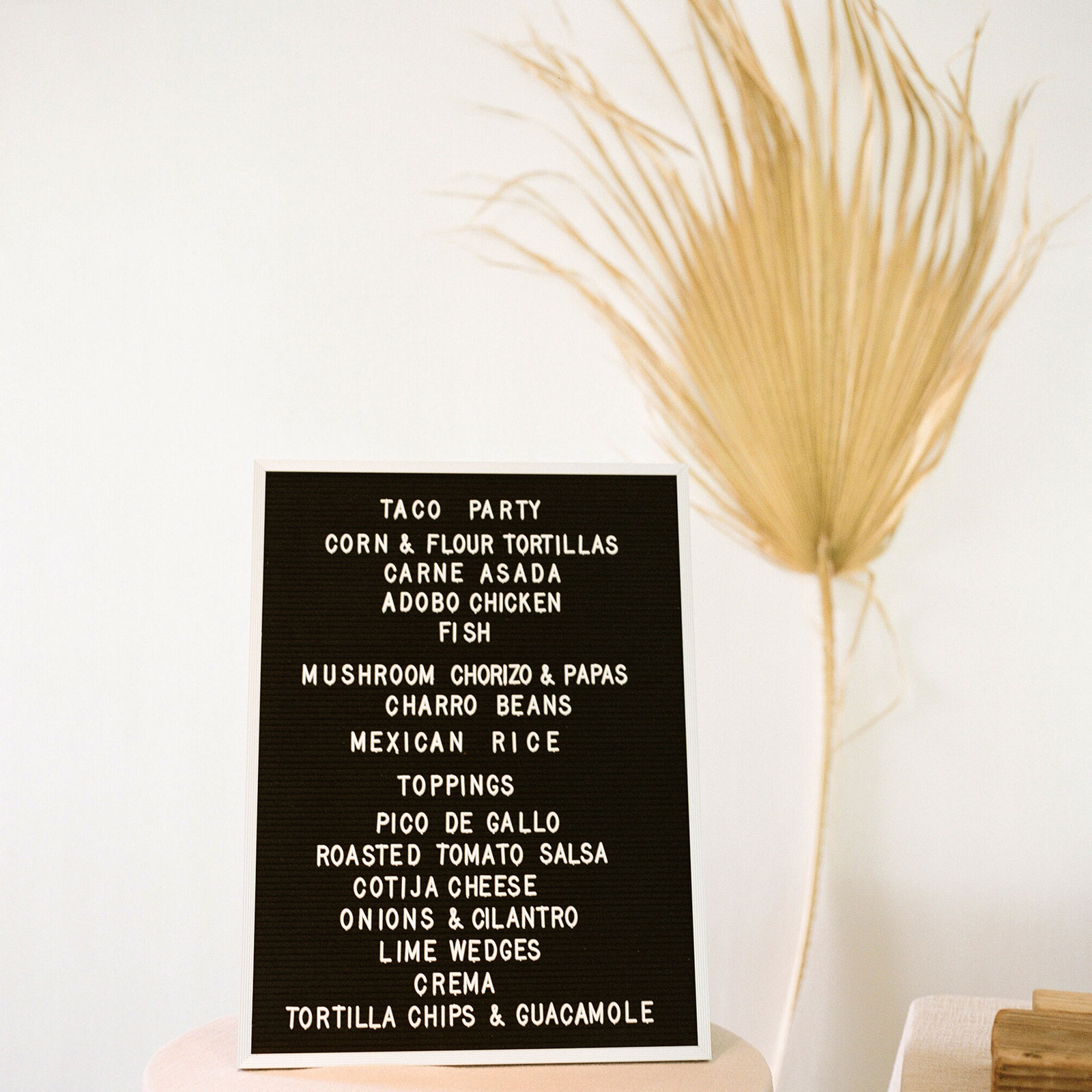 Close up of a black letter board with removable white letters sign saying "taco party" with a list of the nights food options.