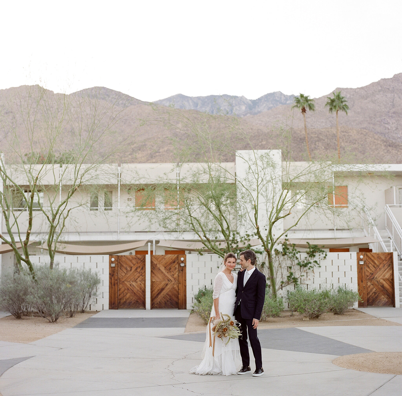 Wide shot of K and E on the property with the mountainscape in the background. The sun has dropped now behind those San Jacintos mountains.