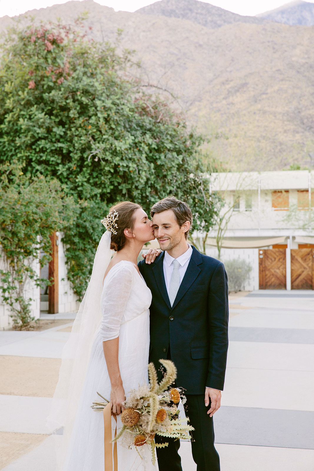 Our couple K and E posing for a portrait on the Ace Hotel grounds in an overcast October day depicting the main walkway with the picturesque San Jacintos mountains far in the background.
