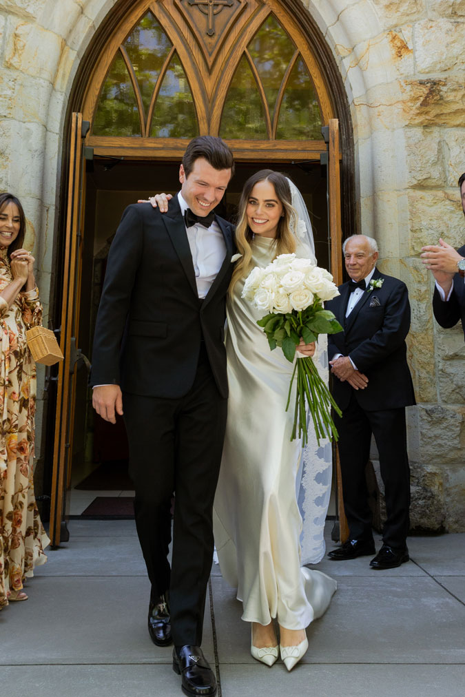 Wide shot of M and C walking towards the camera away from the church.