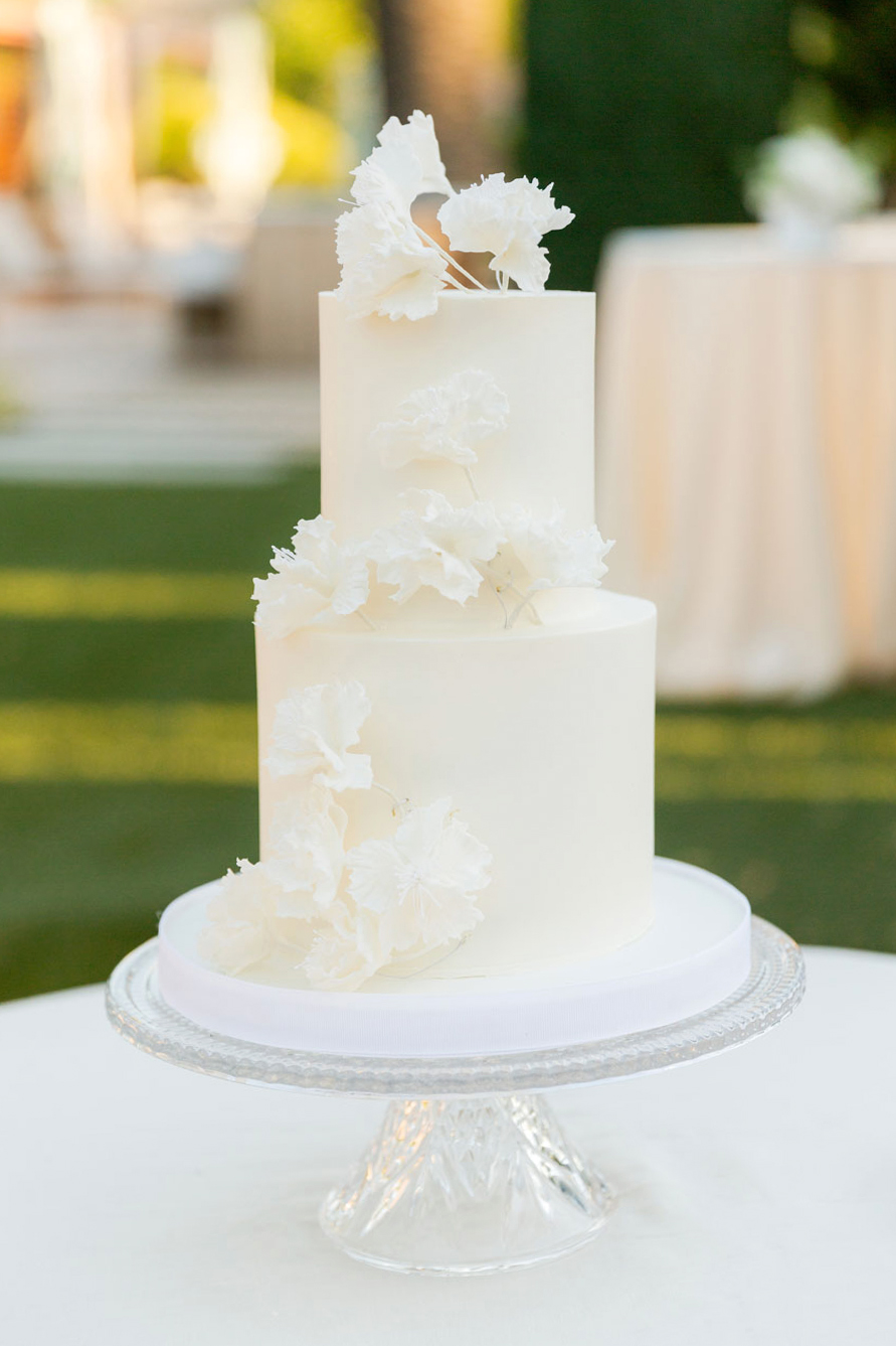 Close up shot of a delicate two tiered white cake.