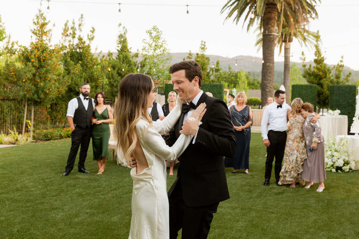 The couple having their first dance as guests look on.