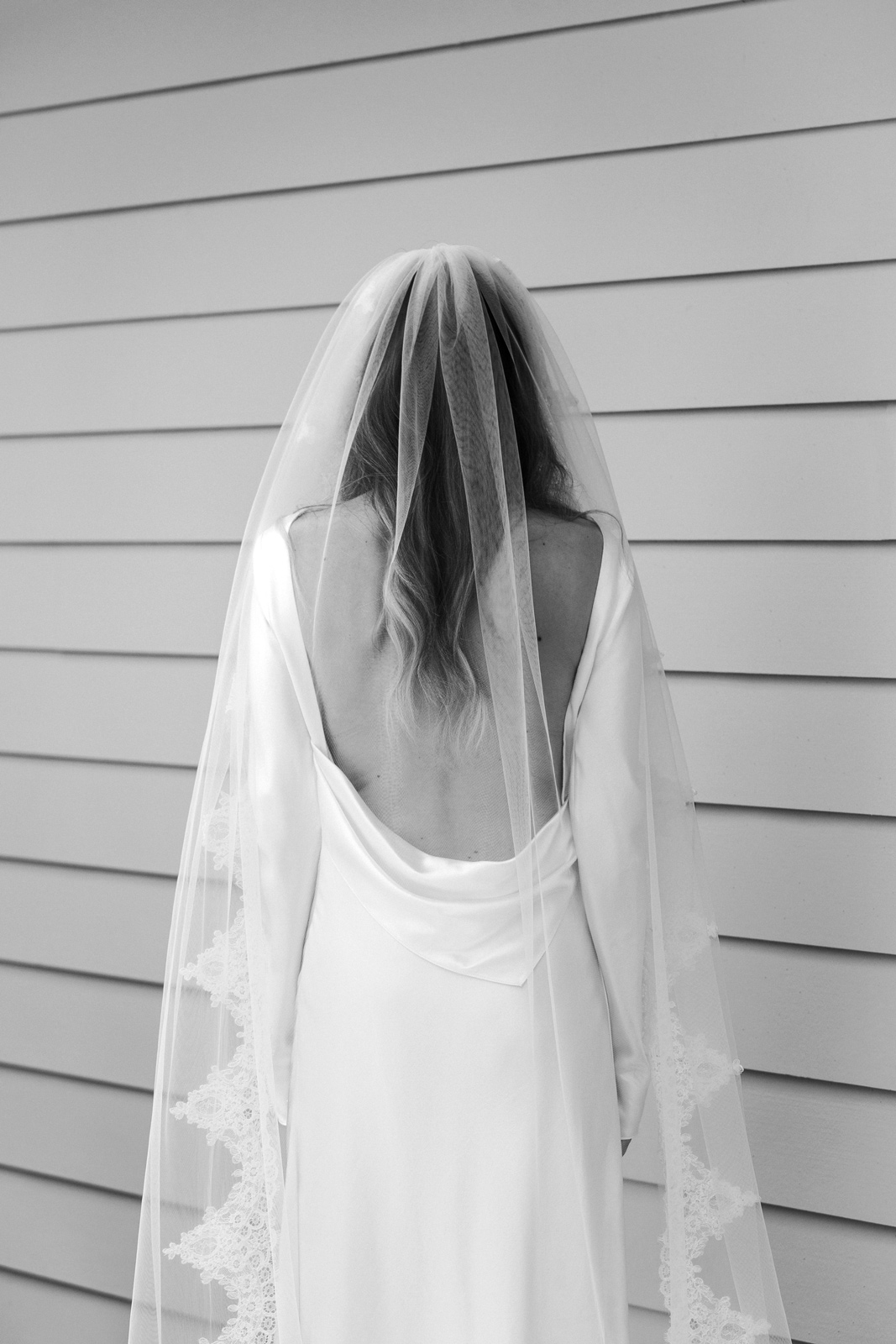 Black and white medium shot of M with her back to the camera.