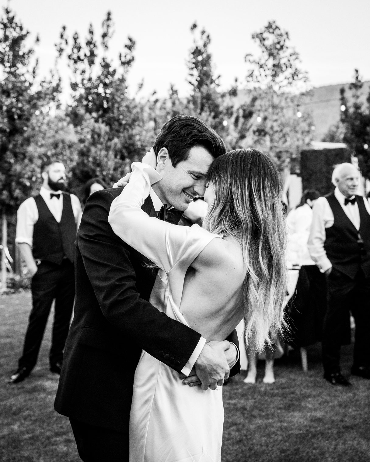 Black and white medium shot of the couple having their first dance looking into each other