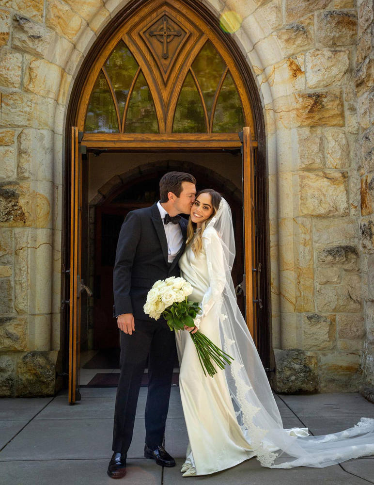 Three wide shots of C and M with her large bridal bouquet in hand that consisted of long stem white roses posing for the camera in front of the church.