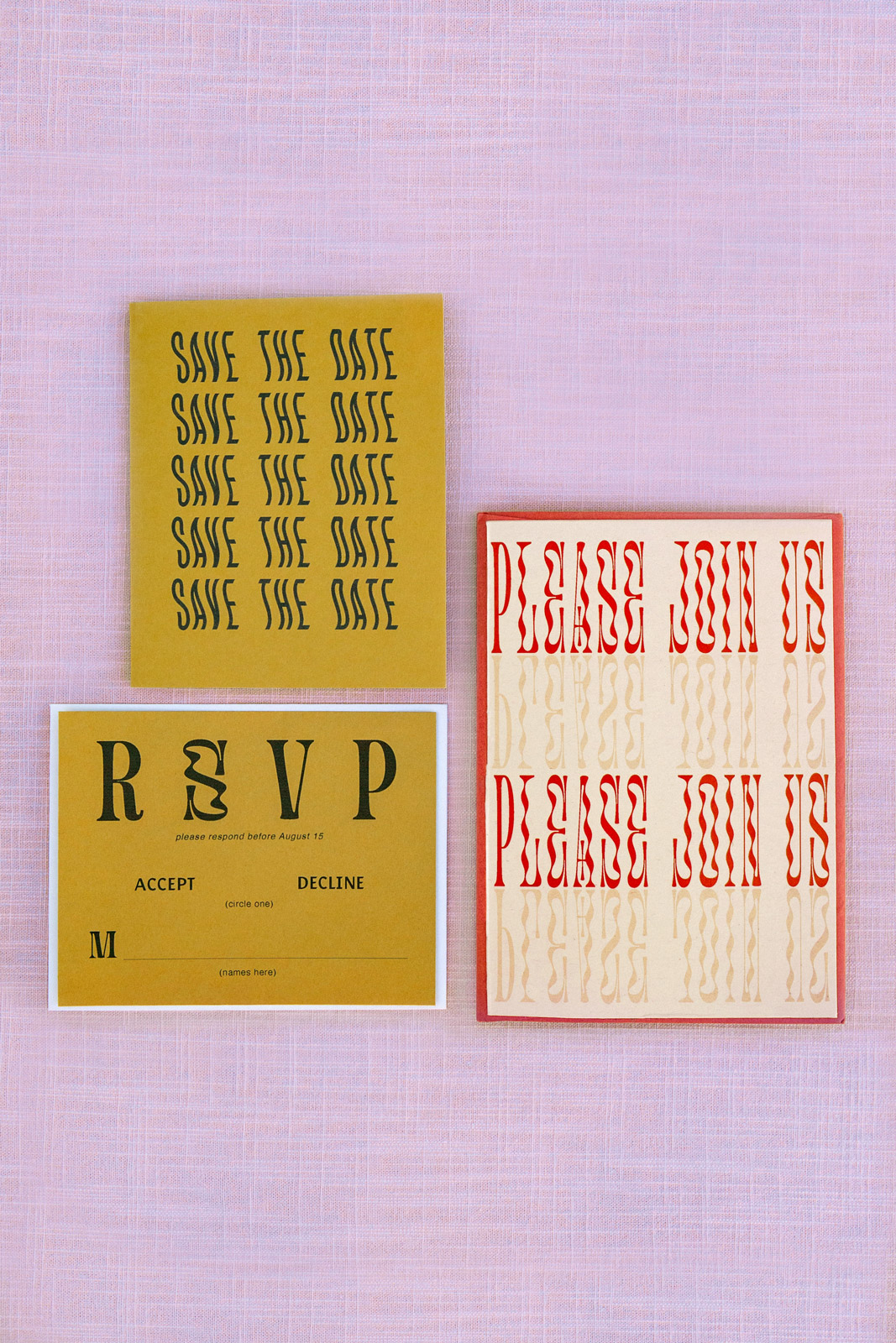 Shot of the invitation suite. With save the date and RSVP cards on avocado green card stock with a wavy style black font and the invitation printed on light pink card stock with red and pink ink. The couple opted for a red envelope to enclose them all. The suite was designed by the couple.