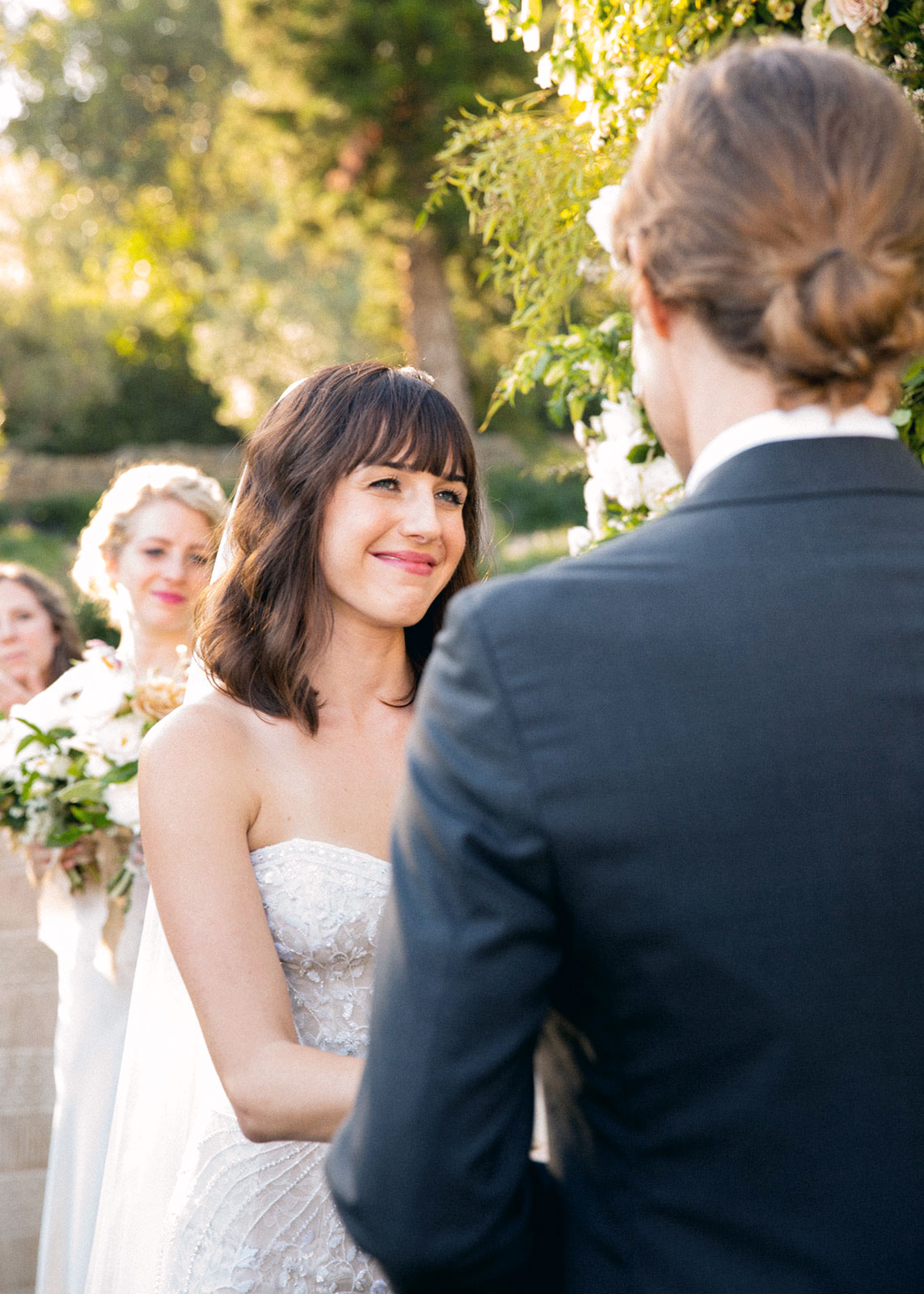 Close up over the should shot of the bride smiling into the grooms eyes.