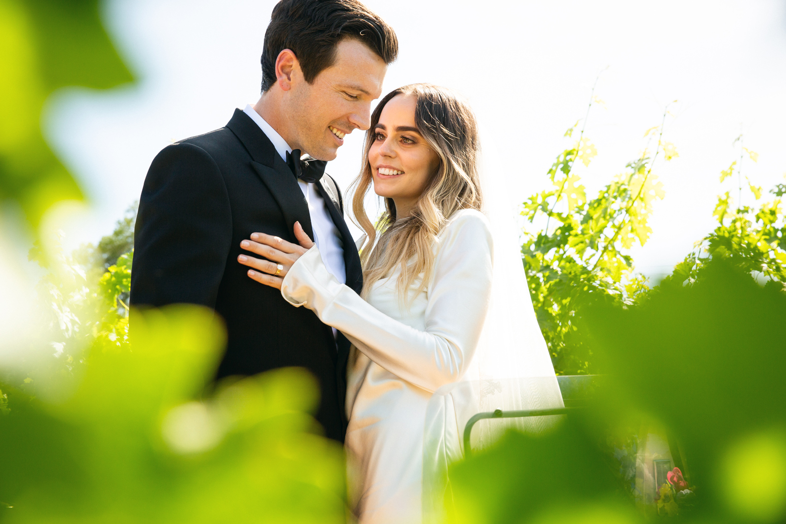 Close up shot of the couple embracing in the grapevines.
