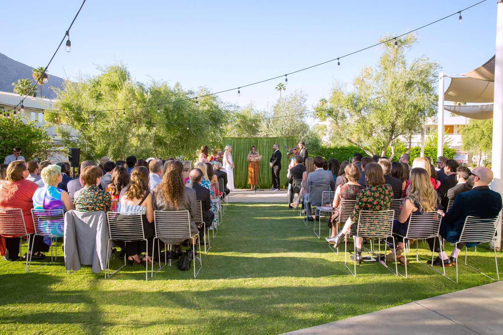 Extreme wide shot of the guests sitting and watching K and B with their officiant Rachel is the couples best friend and who has been a huge part of their life together. She had everyone laughing and in tears throughout her whole speech.