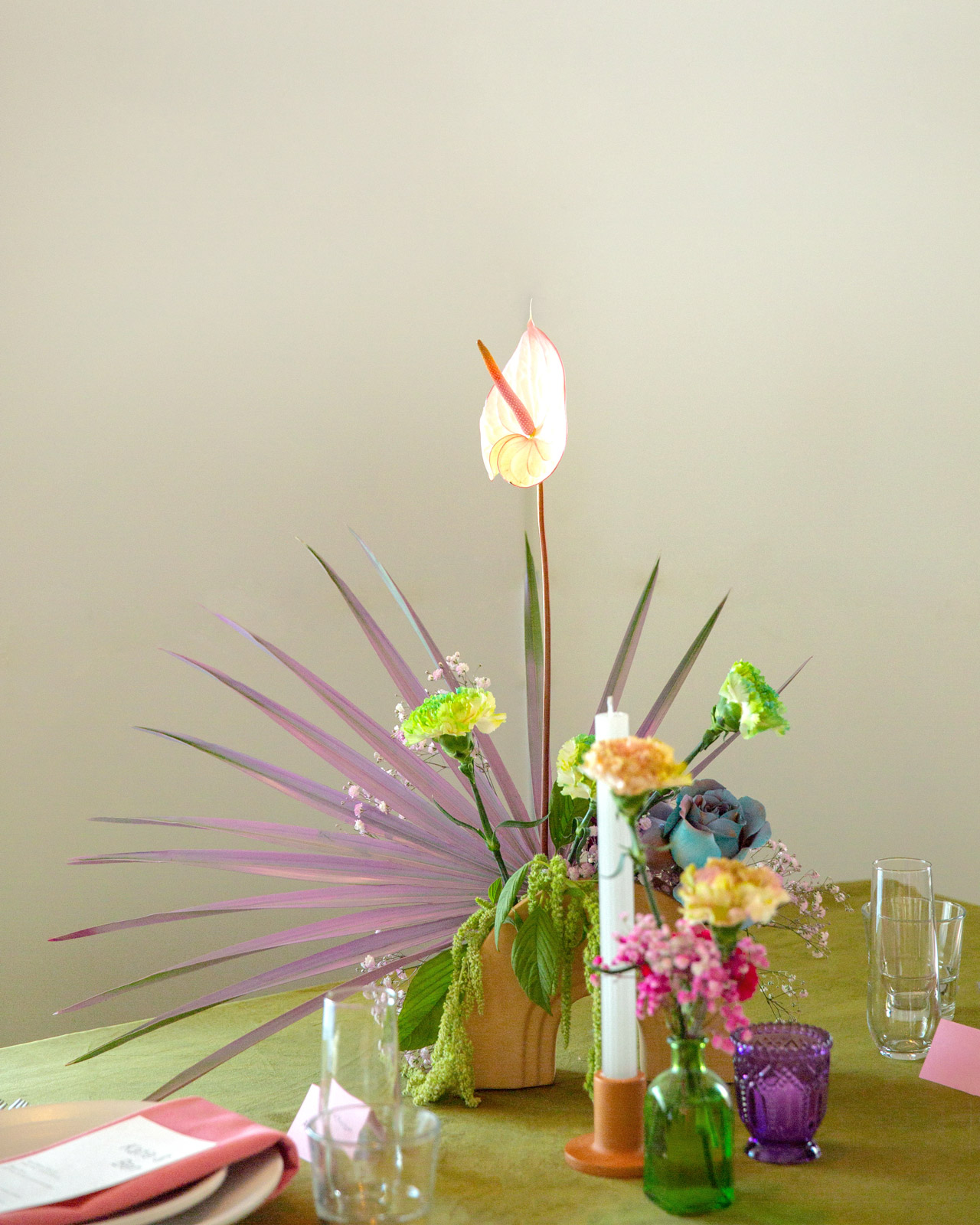 Close up shot of another floral center piece. The star of this centerpiece a white stark Anthurium with a hot pink center.