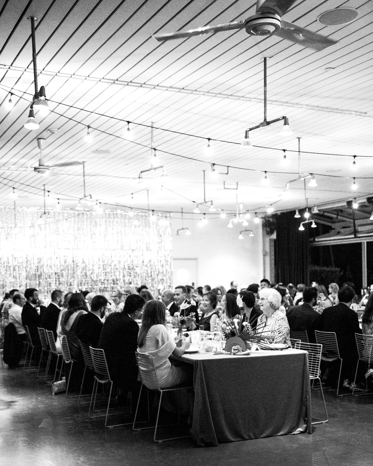 Wide shot of wedding guests enjoying dinner.