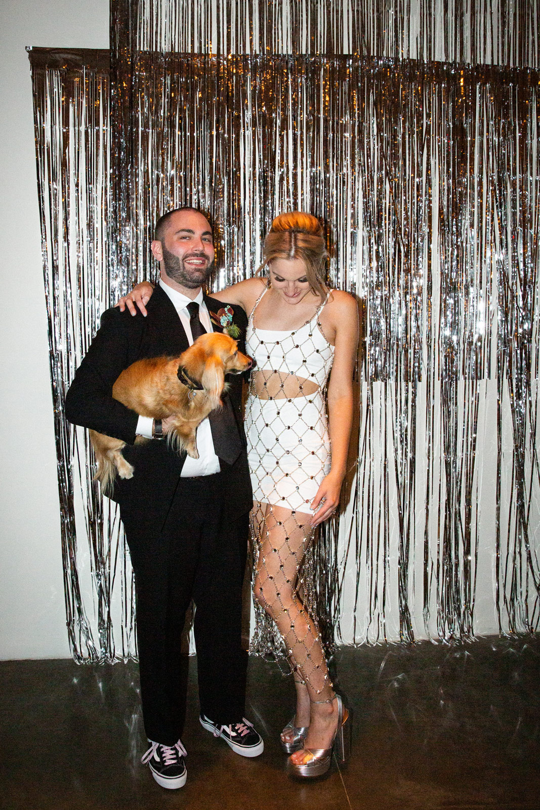 Wide shot of B and K with their dog Raf. K is now wearing a chain link reception dress by Paco Rabanne.