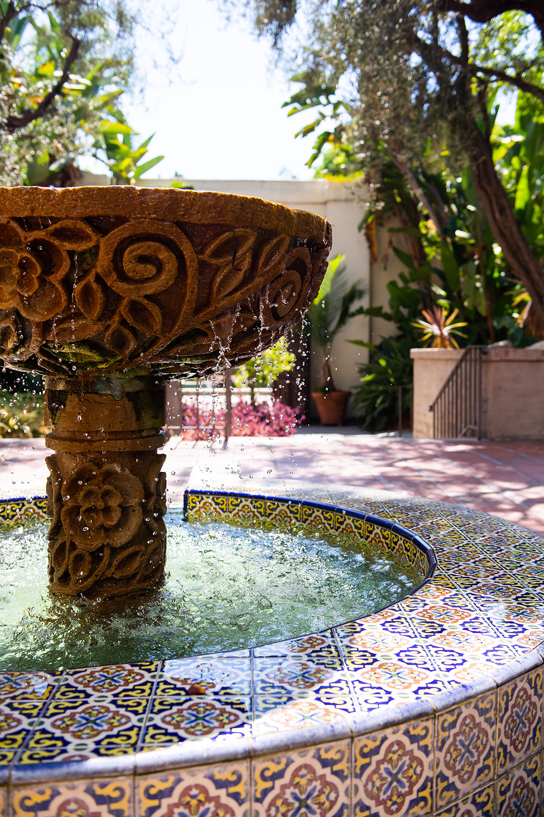 Medium shot of a flowing water fountain set in a tranquil garden environment. The fountain