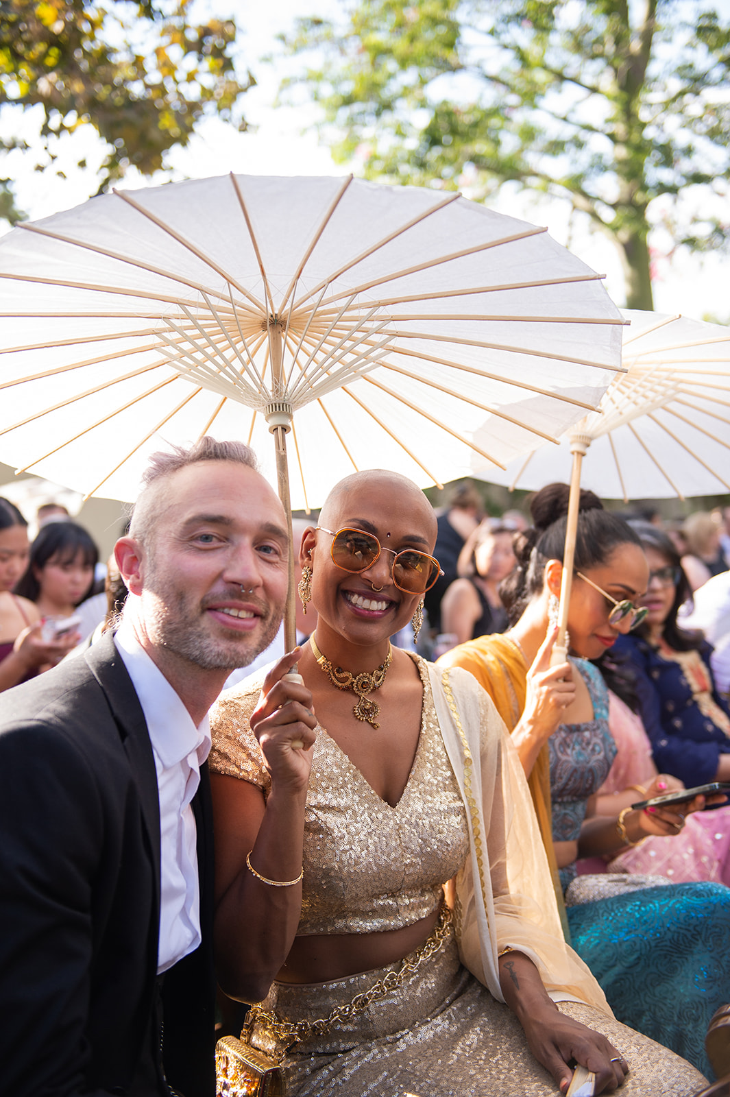 Medium shot of 2 guests holding a white paper umbrella.