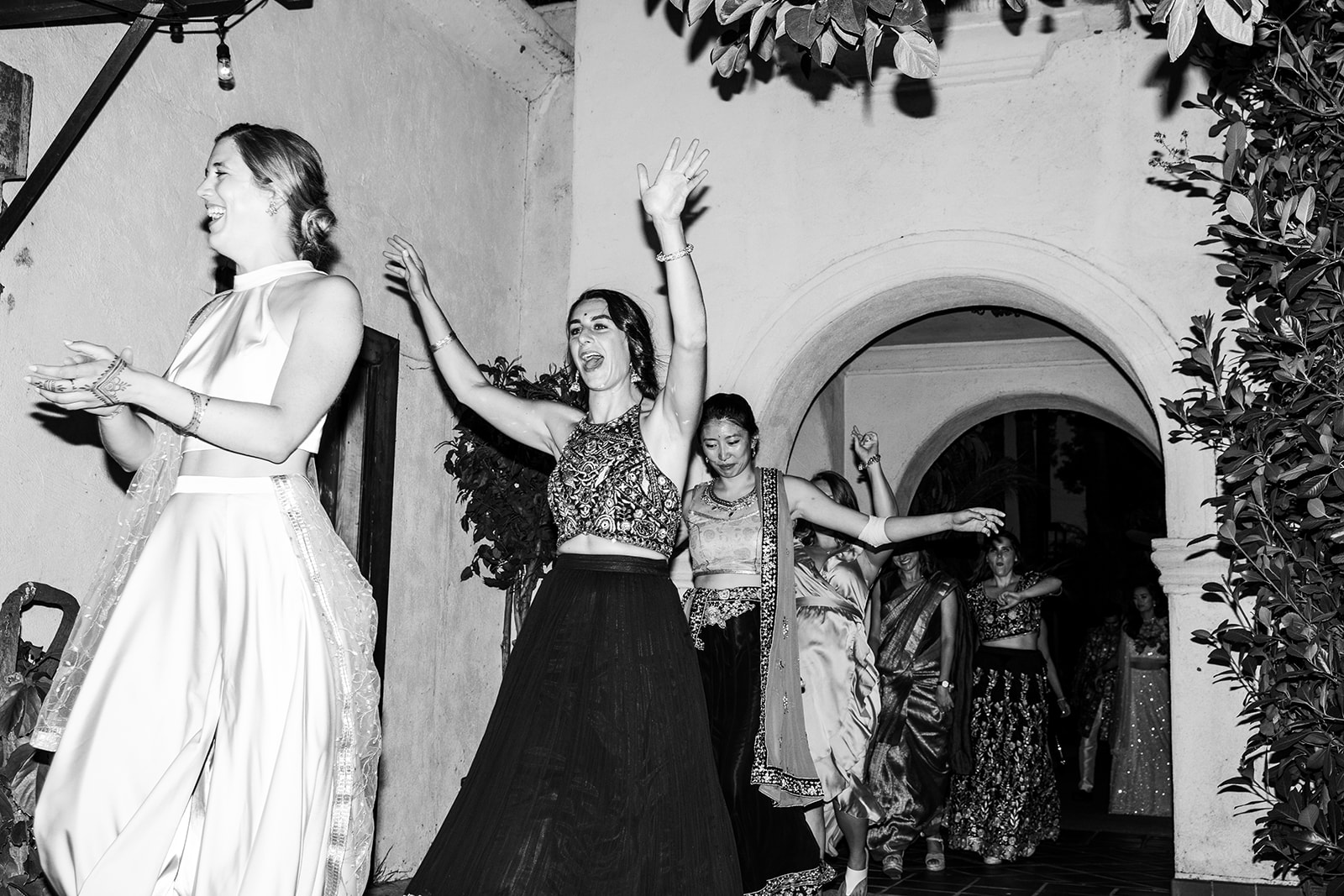 Wideshot in black-and-white of bridesmaids being introduced to the crowd.