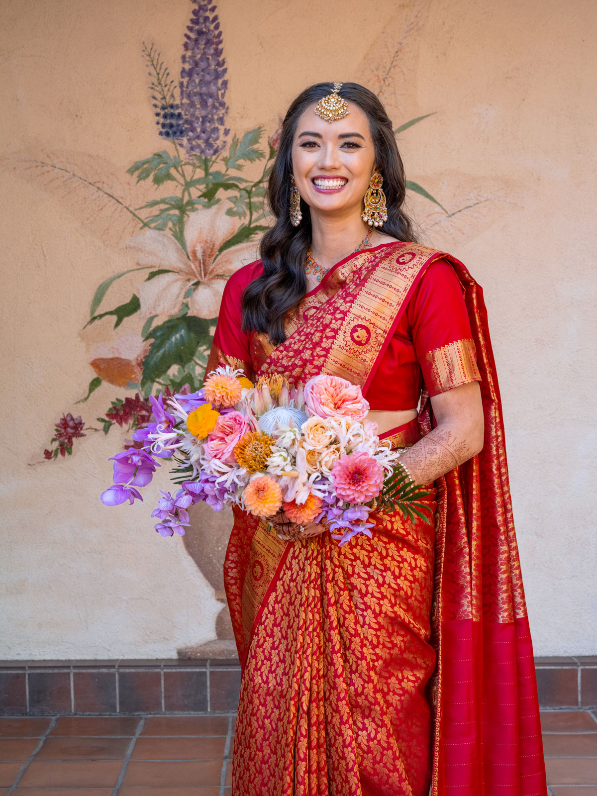 Full body portrait of A holding her bouquet looking straight into the camera.