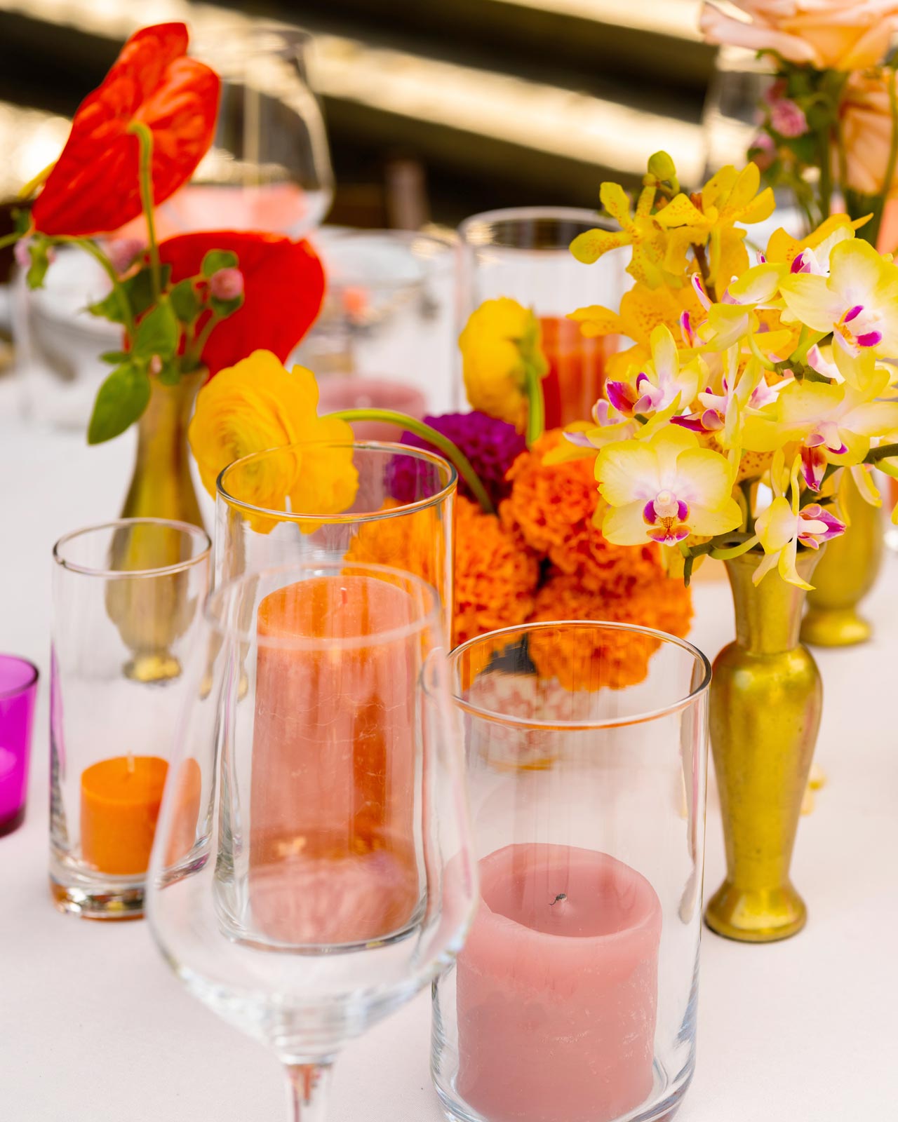 Close-up shot of tablescape showing a small gold vase of yellow orchids.