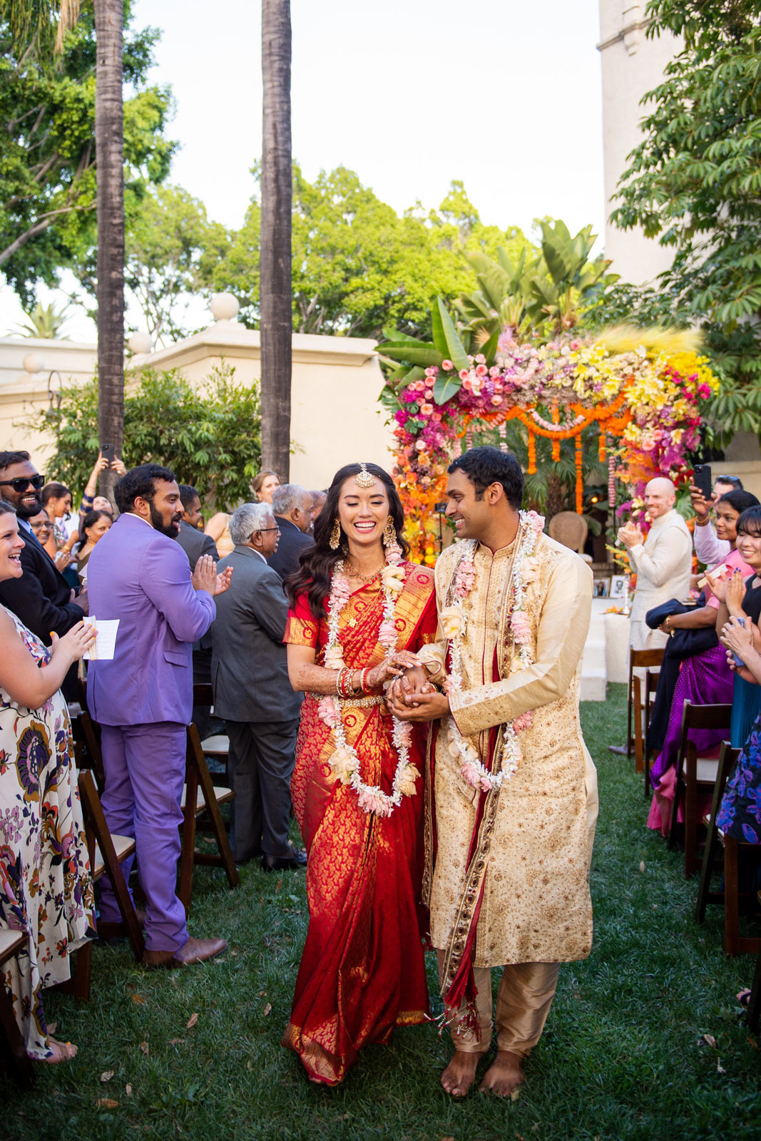A wide shot of A and H walking away from the mandap. Just married!