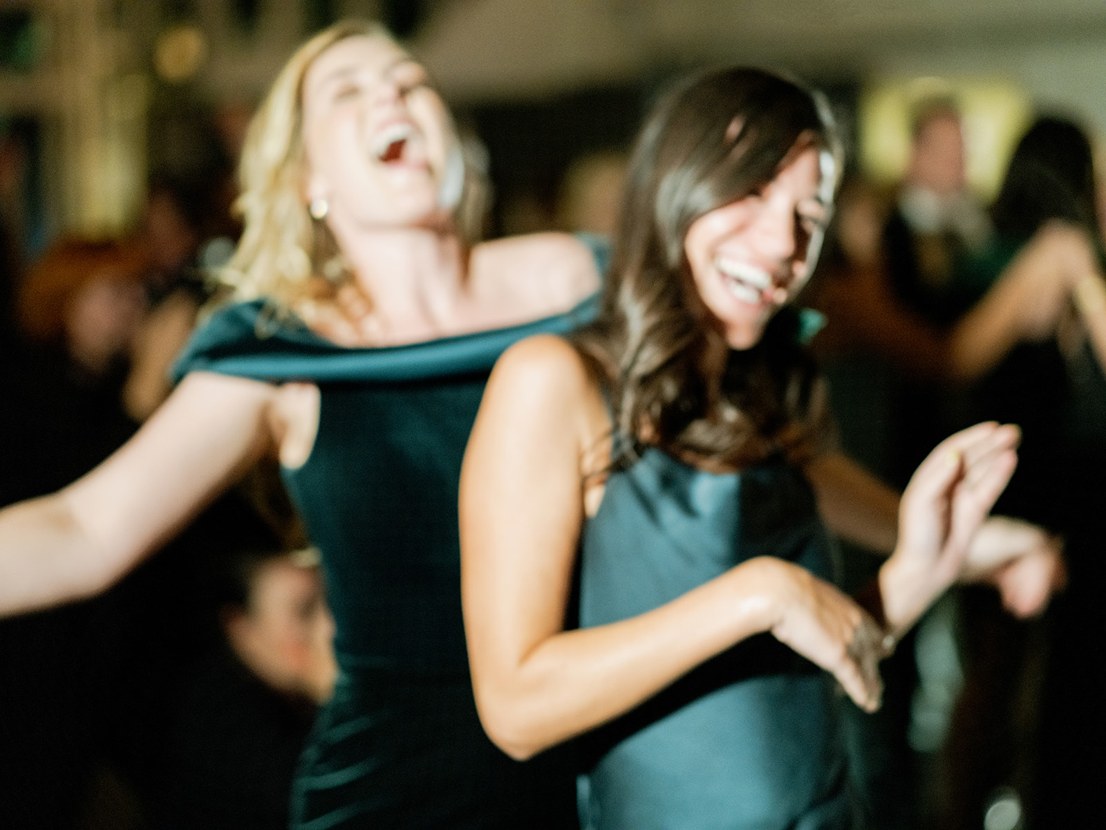 Another candid photo of two bridesmaids caught in a moment in a sort of motion blur.